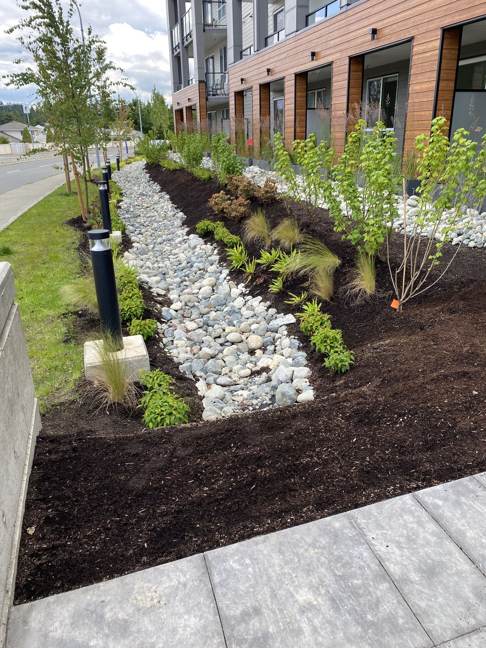 Apartment building with rock bed and plantings